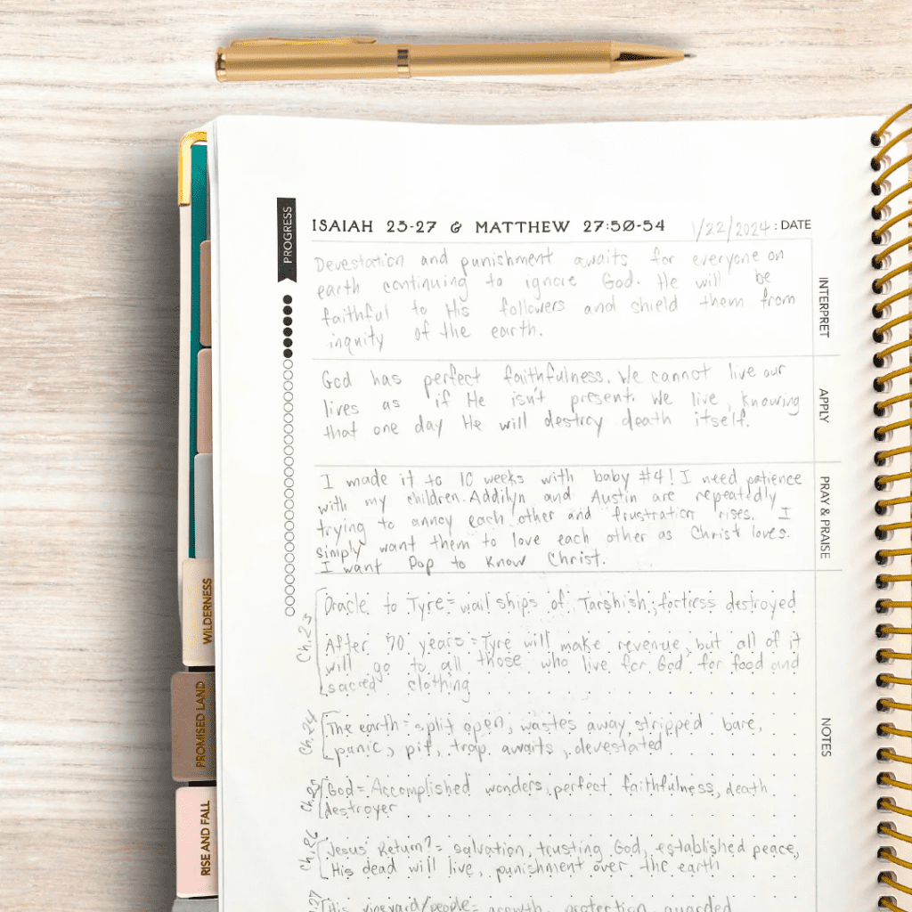 Filled-out Bible journal page featuring reflections on Isaiah and Matthew passages. The page is divided into sections: Interpret, Apply, Pray & Praise, and Notes, with handwritten entries. A gold pen sits at the top of the spiral-bound notebook.